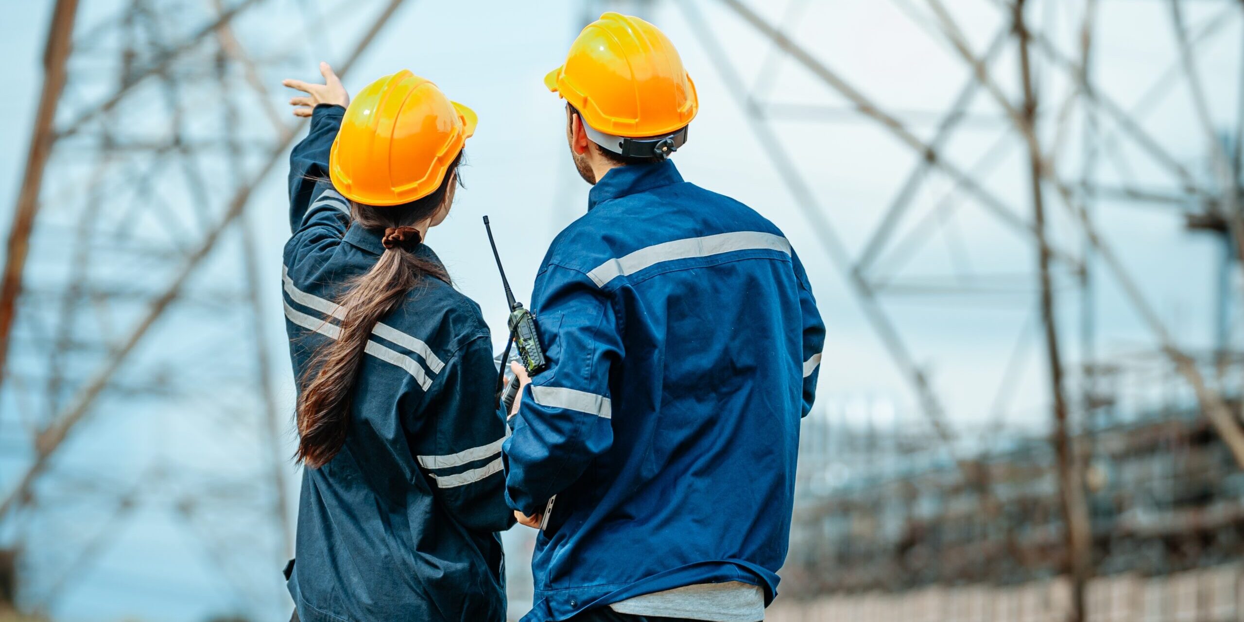 Two,Engineers,In,Yellow,Hard,Hats,And,Blue,Jackets,Analyze